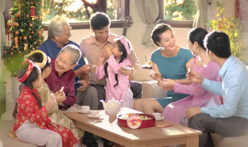 Bé gái mặc áo dài đỏ chúc Tết ông bà